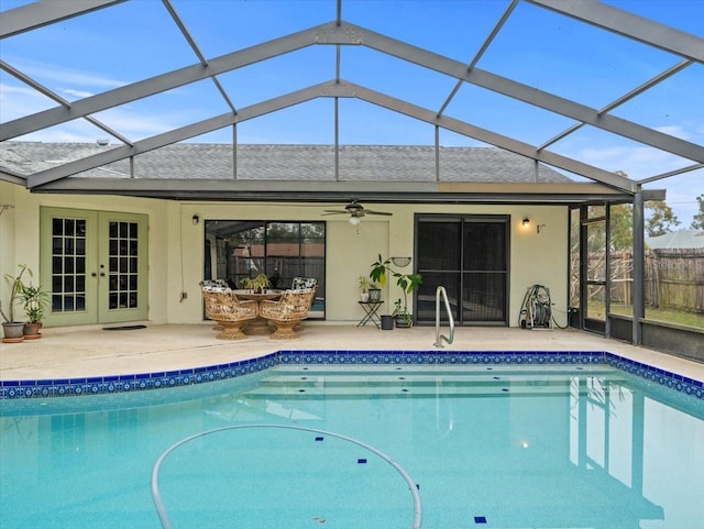 view of swimming pool featuring french doors, a patio area, ceiling fan, and a lanai