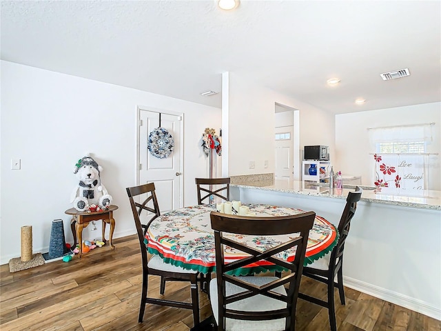 dining space with wood-type flooring and sink