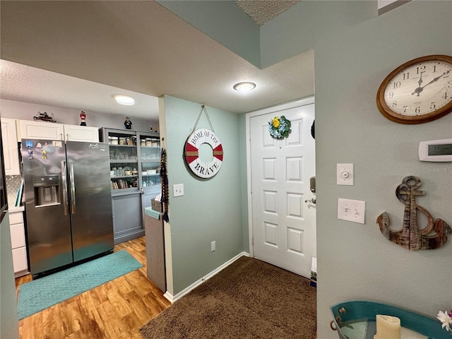 foyer entrance with a textured ceiling and light hardwood / wood-style floors