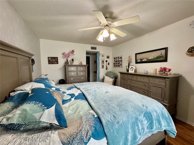 bedroom featuring ceiling fan, dark wood-type flooring, and a textured ceiling