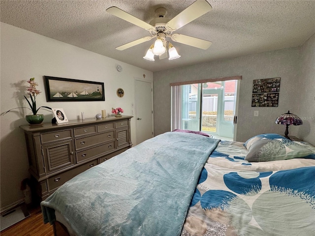 bedroom featuring hardwood / wood-style flooring, ceiling fan, access to exterior, and a textured ceiling