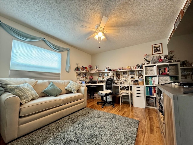 office area with ceiling fan, a textured ceiling, and light hardwood / wood-style flooring