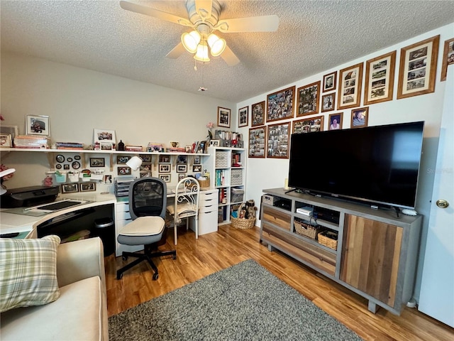 office area with a textured ceiling, light hardwood / wood-style flooring, and ceiling fan