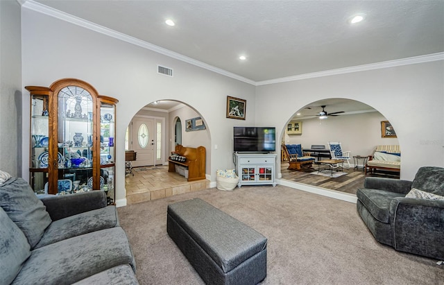 living room featuring light carpet, a textured ceiling, ceiling fan, and ornamental molding