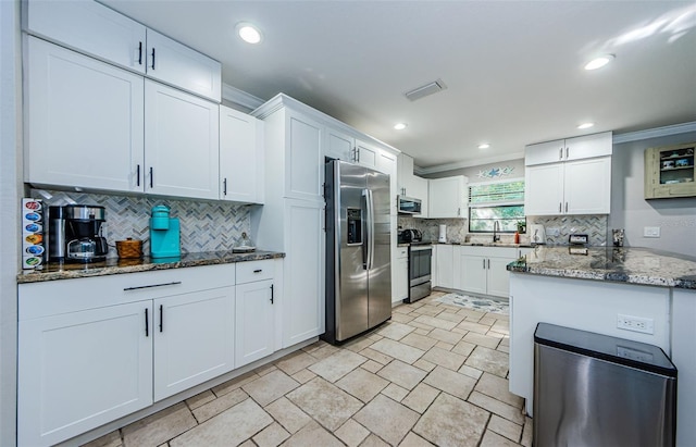 kitchen featuring decorative backsplash, appliances with stainless steel finishes, ornamental molding, stone counters, and white cabinets