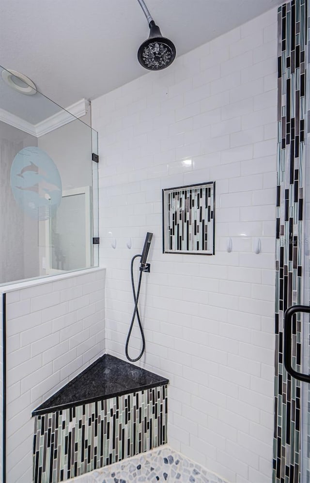 bathroom featuring crown molding and tiled shower