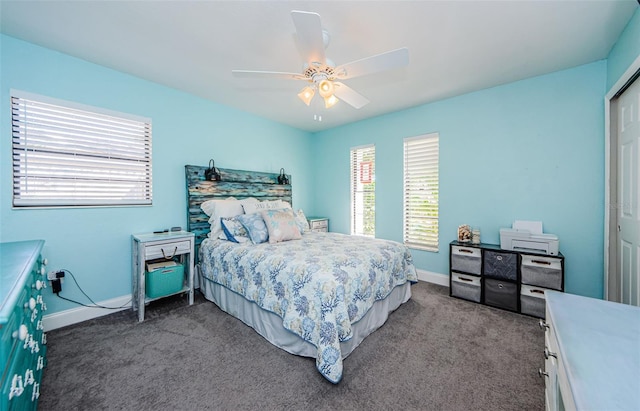 bedroom with ceiling fan, dark carpet, and a closet