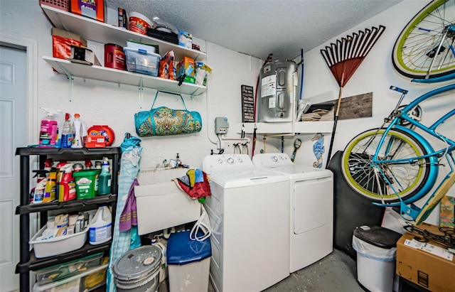 clothes washing area featuring sink, a textured ceiling, and washing machine and clothes dryer