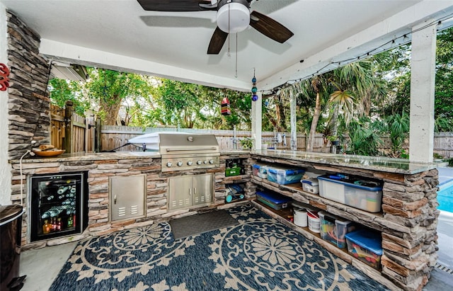 view of patio / terrace with ceiling fan, area for grilling, exterior kitchen, and wine cooler