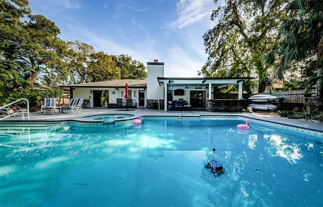 view of pool with a patio area and an in ground hot tub