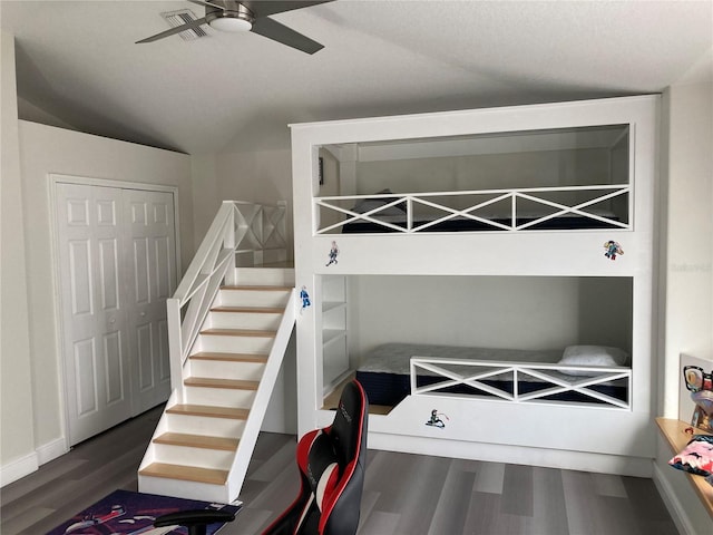 bedroom featuring ceiling fan, dark hardwood / wood-style flooring, a textured ceiling, vaulted ceiling, and a closet