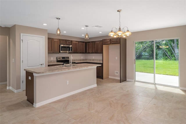 kitchen featuring dark brown cabinets, stainless steel appliances, a center island with sink, an inviting chandelier, and hanging light fixtures