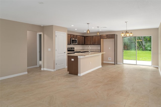 kitchen featuring an inviting chandelier, sink, decorative light fixtures, dark brown cabinets, and stainless steel appliances