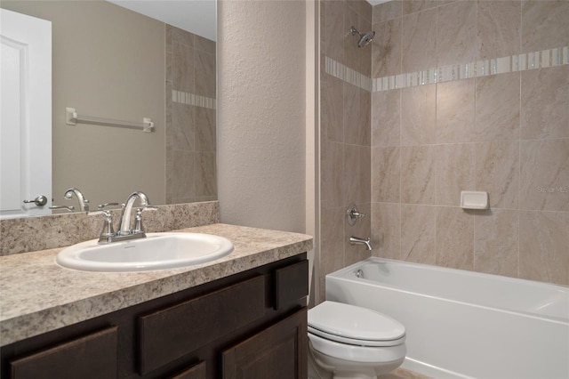 full bathroom with vanity, tiled shower / bath combo, and toilet