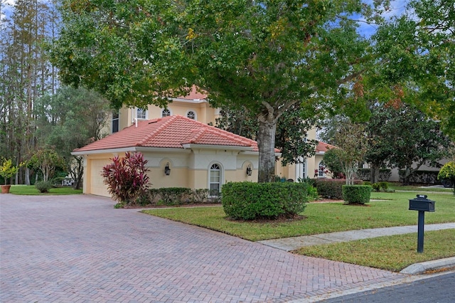 mediterranean / spanish-style home with a garage and a front yard