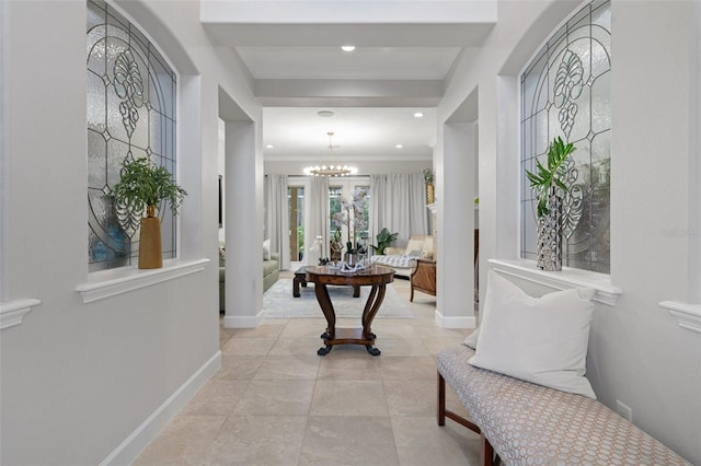 hall featuring ornamental molding, light tile patterned floors, and a notable chandelier