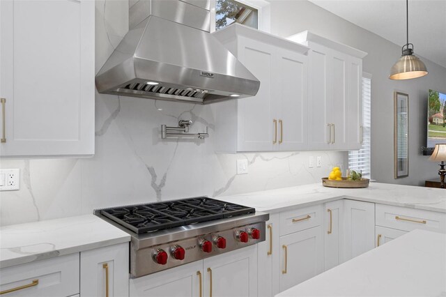 kitchen featuring decorative backsplash, white cabinetry, stainless steel gas stovetop, and wall chimney exhaust hood