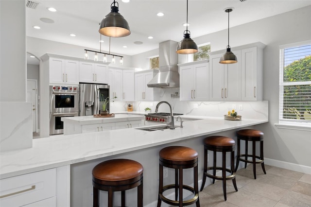 kitchen featuring kitchen peninsula, appliances with stainless steel finishes, and pendant lighting