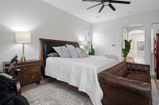 bedroom featuring hardwood / wood-style floors, ceiling fan, and multiple windows