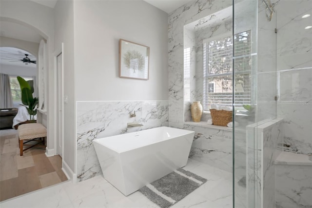 bathroom with ceiling fan, tile walls, and shower with separate bathtub