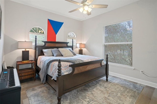 bedroom featuring hardwood / wood-style floors, multiple windows, and ceiling fan