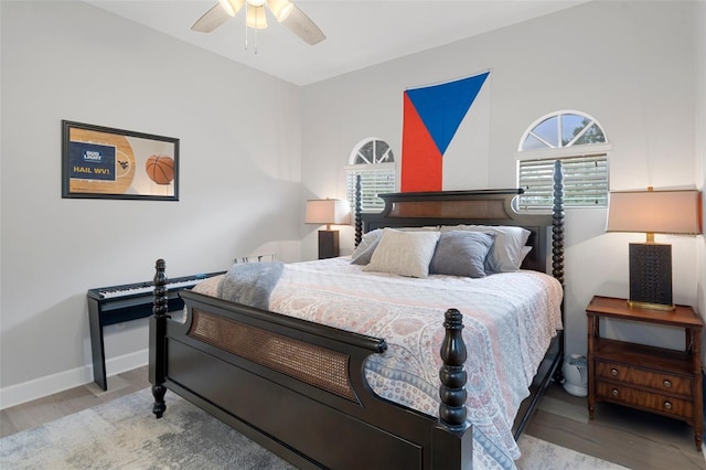 bedroom featuring ceiling fan, light hardwood / wood-style floors, and multiple windows