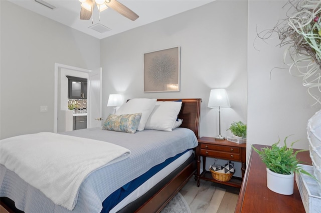 bedroom with hardwood / wood-style floors, ceiling fan, and ensuite bathroom