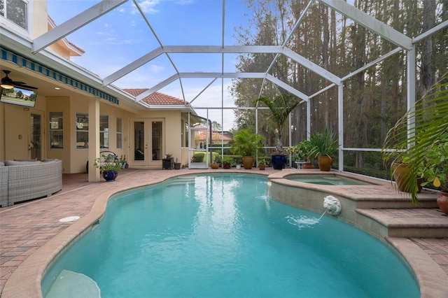 view of swimming pool with french doors, a lanai, pool water feature, a patio area, and an in ground hot tub