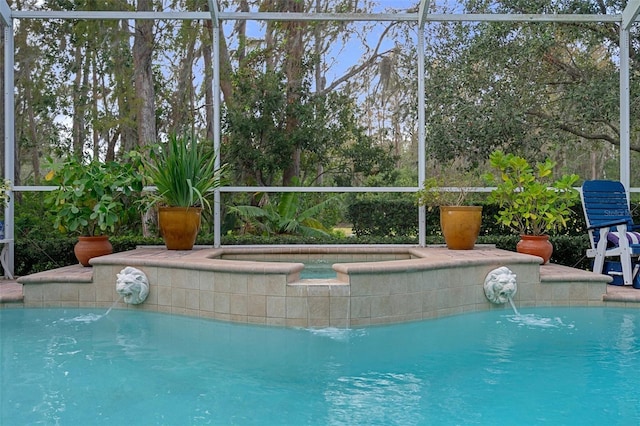 view of swimming pool with pool water feature, a lanai, and an in ground hot tub