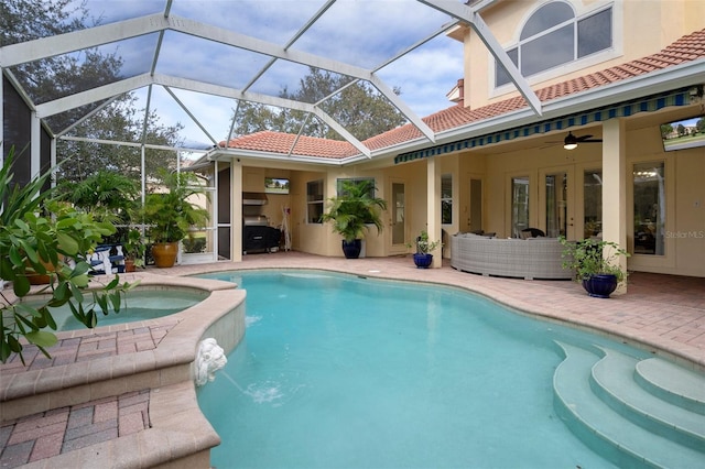 view of swimming pool with ceiling fan, a patio area, a lanai, and an in ground hot tub