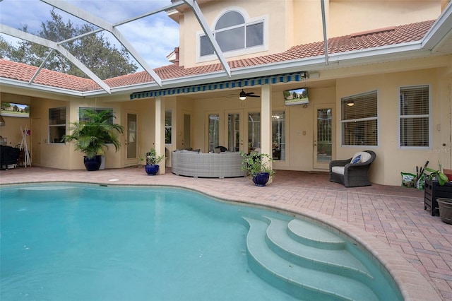 rear view of property featuring ceiling fan, a lanai, and a patio