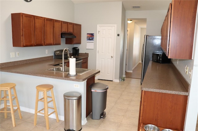 kitchen with a breakfast bar area, kitchen peninsula, sink, and stainless steel appliances