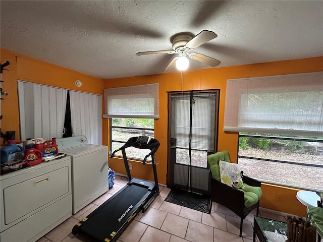 exercise room with ceiling fan, light tile patterned flooring, independent washer and dryer, and a textured ceiling