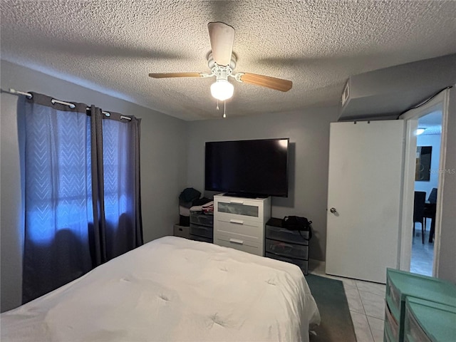 tiled bedroom with ceiling fan and a textured ceiling