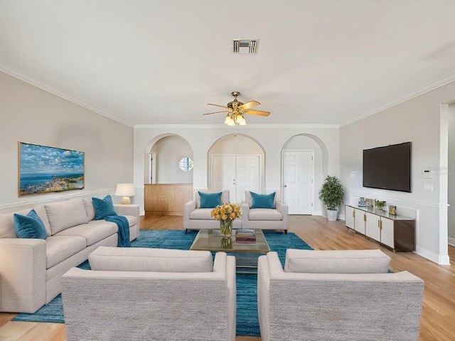 living room with crown molding, ceiling fan, and light hardwood / wood-style floors