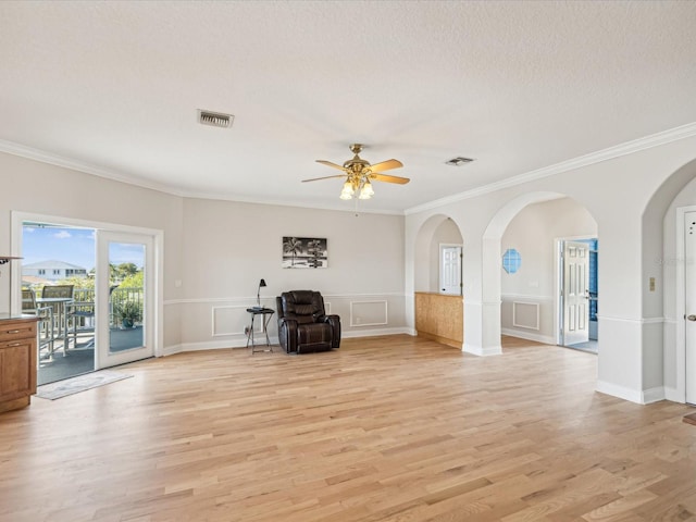 unfurnished living room with a textured ceiling, light hardwood / wood-style flooring, ceiling fan, and crown molding