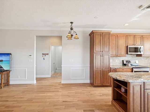 kitchen featuring backsplash, stainless steel appliances, decorative light fixtures, light hardwood / wood-style flooring, and a notable chandelier