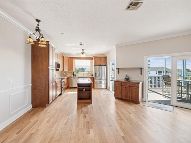 kitchen featuring a center island, hanging light fixtures, plenty of natural light, light hardwood / wood-style floors, and appliances with stainless steel finishes