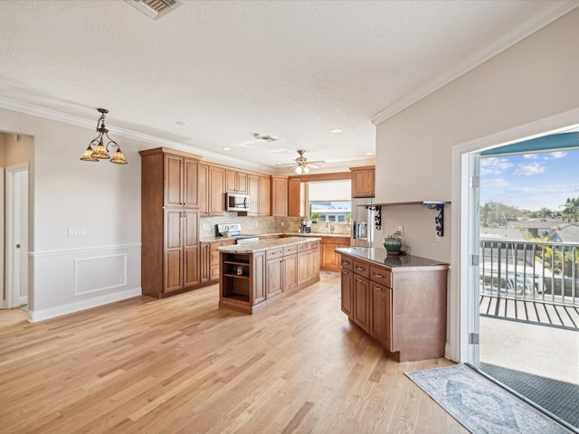 kitchen with a center island, hanging light fixtures, ornamental molding, light hardwood / wood-style floors, and stainless steel appliances