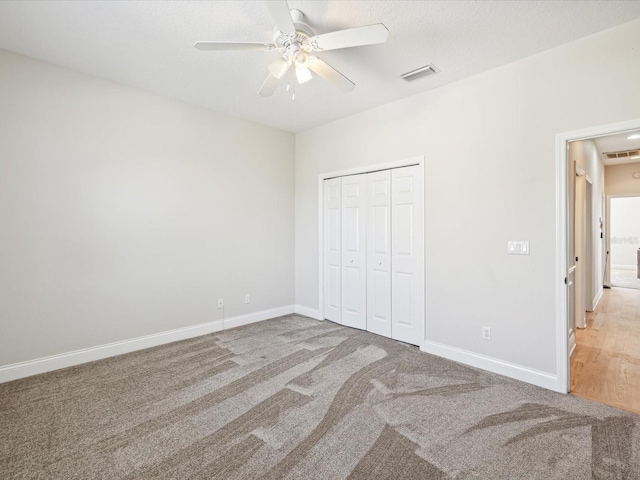 unfurnished bedroom with carpet, a closet, and ceiling fan