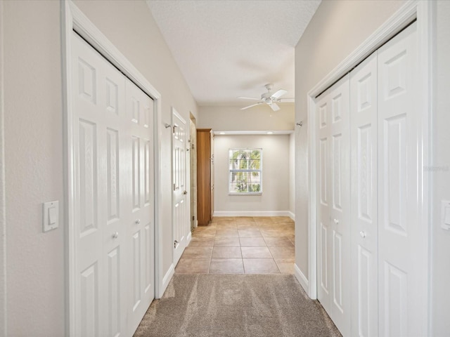 hallway featuring light tile patterned floors and a textured ceiling