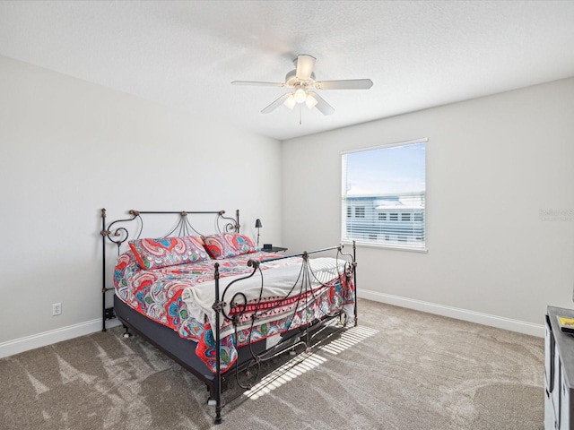 bedroom with ceiling fan, carpet, and a textured ceiling