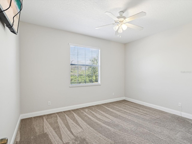 carpeted empty room with ceiling fan and a textured ceiling