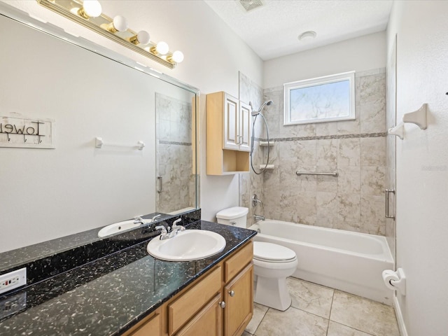 full bathroom with vanity, tiled shower / bath, tile patterned flooring, toilet, and a textured ceiling