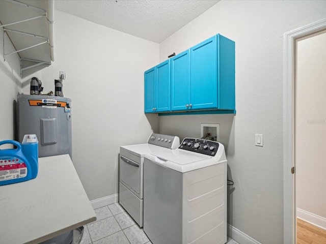 laundry area featuring cabinets, electric water heater, independent washer and dryer, a textured ceiling, and light tile patterned floors