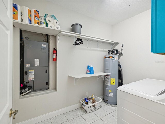 washroom with light tile patterned floors, electric water heater, separate washer and dryer, and a textured ceiling