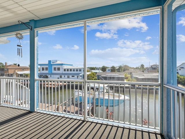 sunroom / solarium featuring a water view