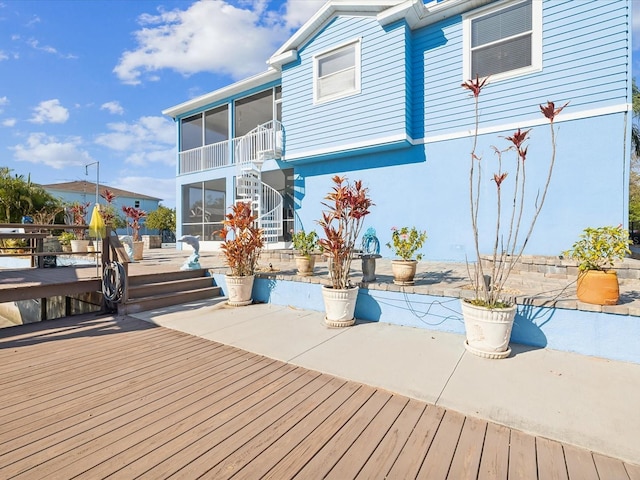 wooden deck with a patio area and a sunroom