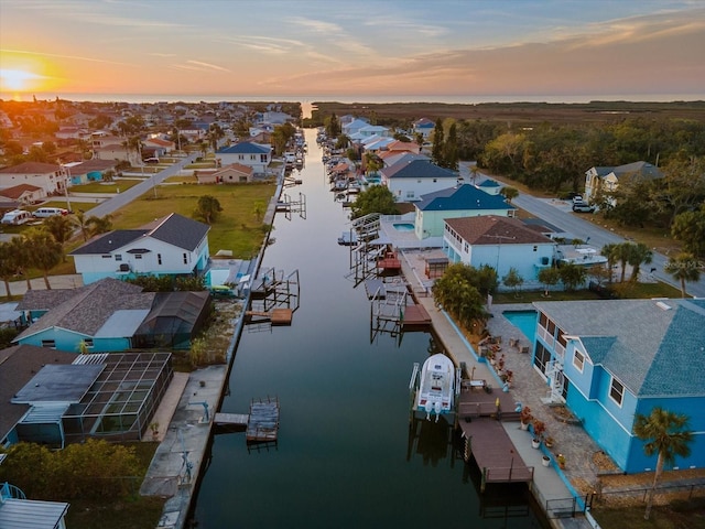 aerial view at dusk featuring a water view