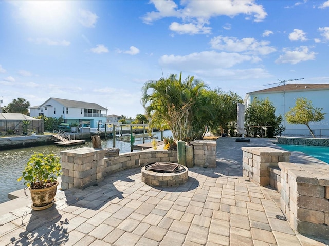 view of patio / terrace with a water view, a dock, and an outdoor fire pit